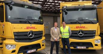 Véhicules Fraikin DHL stationnés avec deux personnes devant